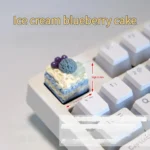 A collection of handcrafted artisan dessert keycaps, showcasing realistic miniature ice cream and cake designs from various vibrant angles.