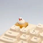 Exquisite handcrafted 3D artisan Java Sparrow keycap, showcasing its intricate miniature scene and charming bird detail from a captivating angle.