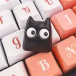 Artistic side view of the unique Little Black Cat artisan resin ESC keycap, highlighting its intricate, handcrafted design and translucent charm.