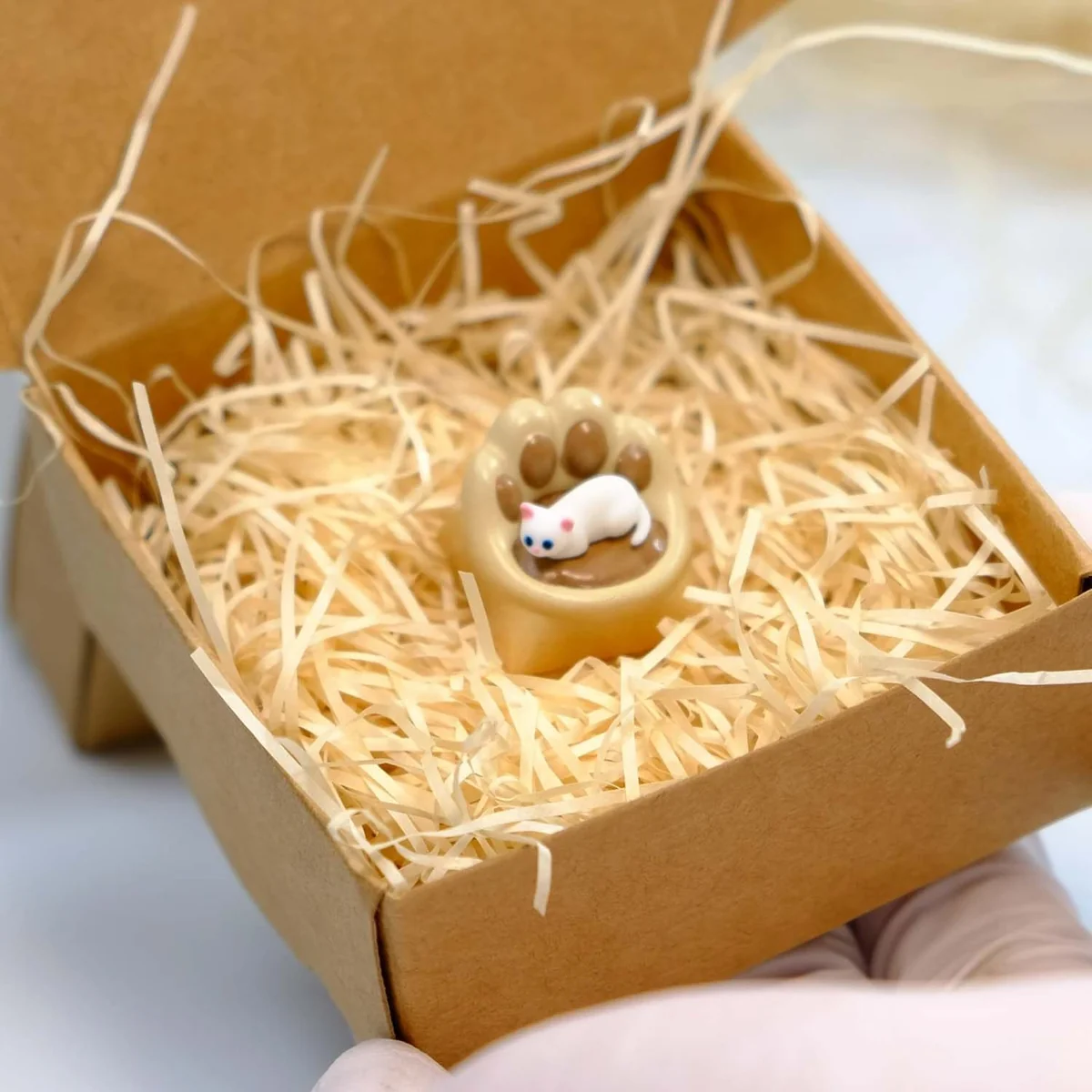 Whimsical handcrafted magnetic 3D Cat Paw Sofa Artisan Keycaps, showcasing its tiny blue eyes and cozy sofa perch from a charming perspective.