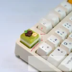 Mousse Cake Artisan Keycap. Unique dessert design, vibrant pastel colors, realistic mousse texture, shown in multiple views. Whimsical, playful.
