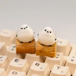 Handcrafted whimsical Bushtit artisan keycap showcasing its adorable 3D sculpted form from a charming front-side perspective on a rustic log.