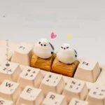 Whimsical Bushtit artisan keycap, handmade, showcasing an adorable 3D sculpted forest bird on a rustic log from an alternate view, highlighting its charming design.