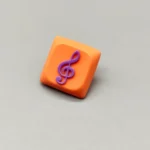Handcrafted Treble Clef Low Shaft Keycaps featuring a vibrant resin treble clef on a playful orange base. This unique musical note MX keycap enhances any keyboard.
