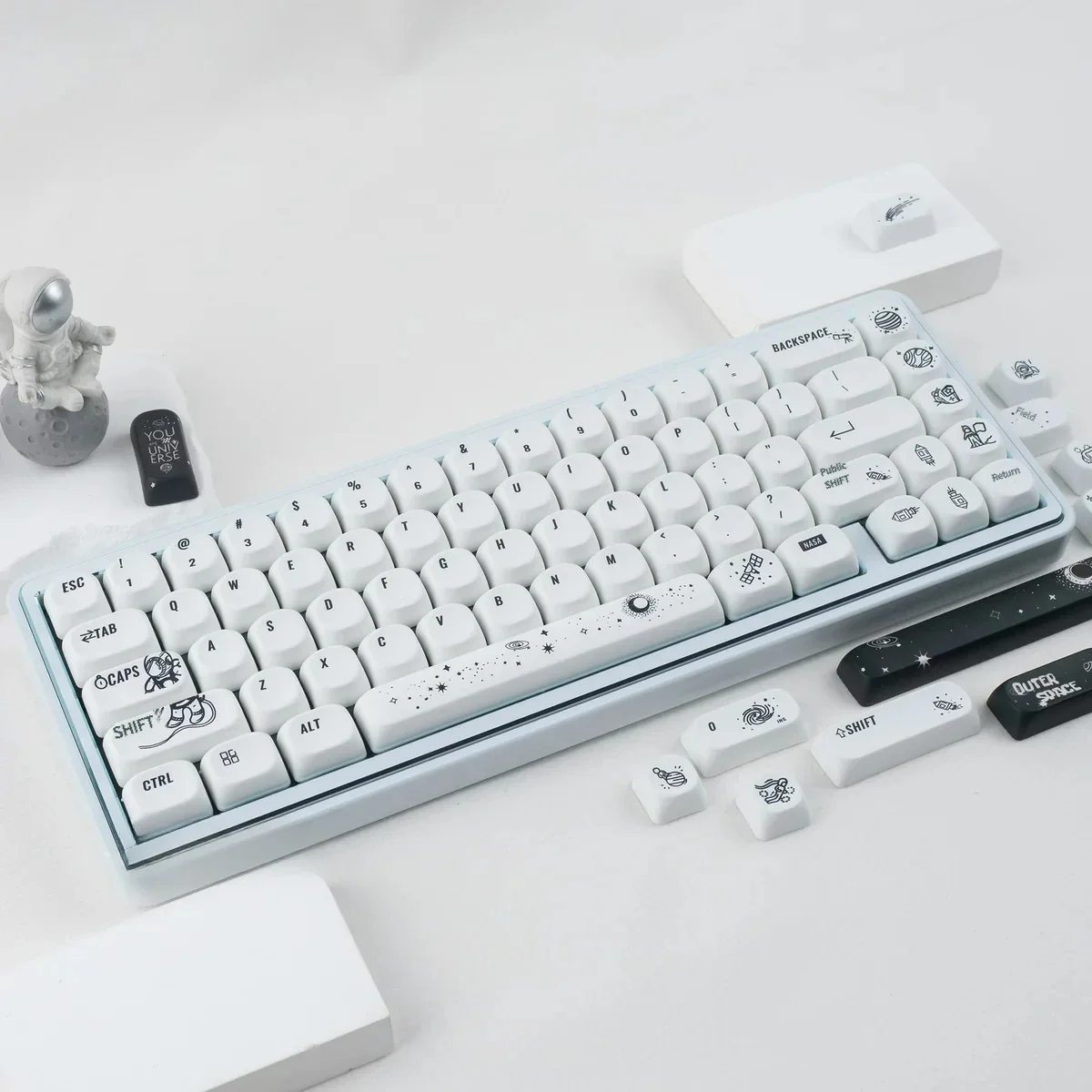 Astronaut PBT MOA keycap set displayed from various angles, revealing durable PBT and ergonomic profile, with captivating cosmic artistry and stylized.
