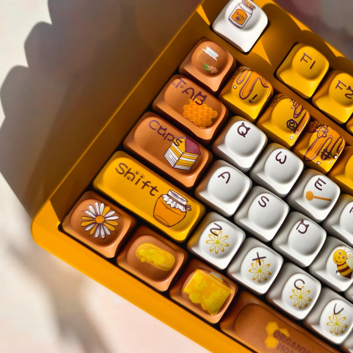 Vibrant PBT dye-sub bee keycaps set showcase charming bee, honeycomb, and flower motifs from various angles, bringing honeycomb joy.