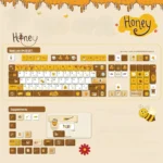 Close-up views of vibrant Honey Buzz Bee PBT Keycaps Set, showcasing charming dye-sub bee, honeycomb, and flower designs from various angles.