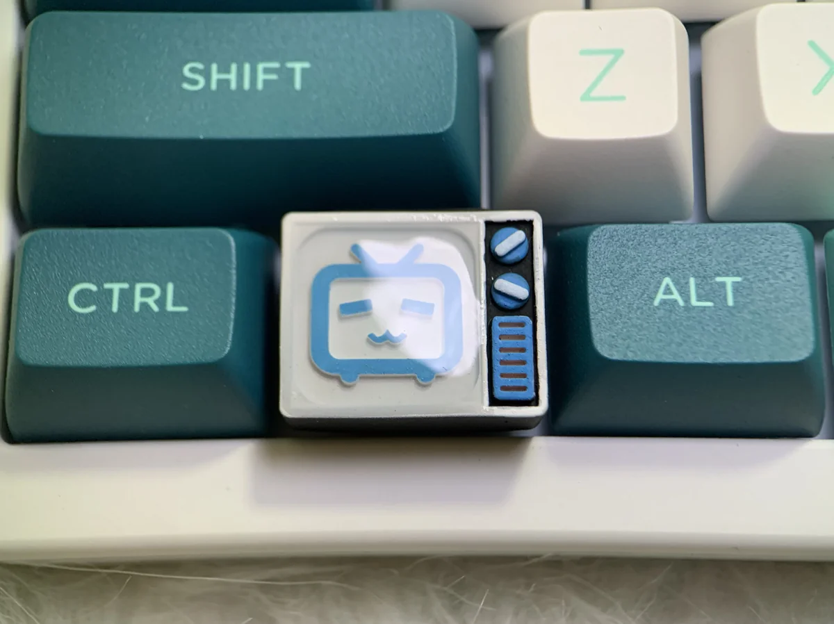 A gallery of the playful BiliBili Pixel TV keycap, showcasing its handcrafted resin art, retro design, and backlit detailing from various angles.