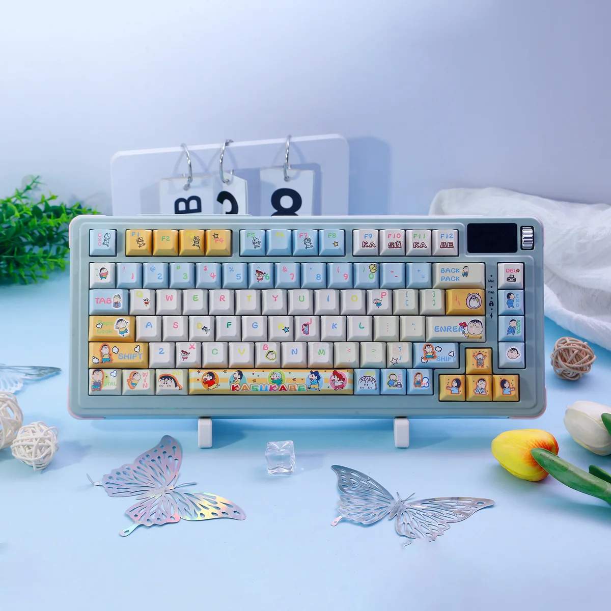 A playful Bo-chan Daily Charm PBT keycap set featuring exclusive Crayon Shin-chan Bo-chan art in a serene blue palette, showcasing whimsical daily life.