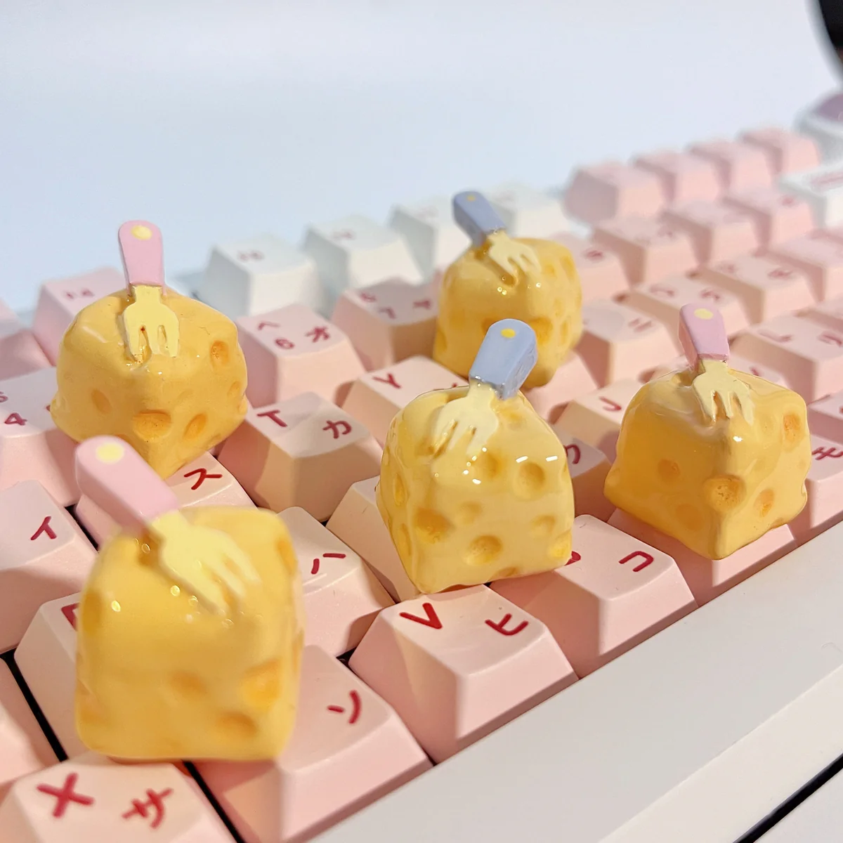 Adorable handcrafted cheesecake artisan keycap, showcasing its whimsical miniature form and playful fork detail from multiple perspectives.