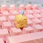 Handcrafted whimsical cheesecake artisan keycap gallery, showing its adorable miniature realism and playful fork detail from multiple charming angles.