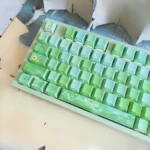 Gallery of poetic Chinese art keycaps set, backlit, featuring tranquil ancient landscapes, green plums, and rain. Shows exquisite detail from multiple view angles.