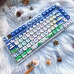 Festive Blue PBT Christmas Keycaps Set, featuring durable PBT and charming blue and white winter wonderland icons, captured from an artistic angle.