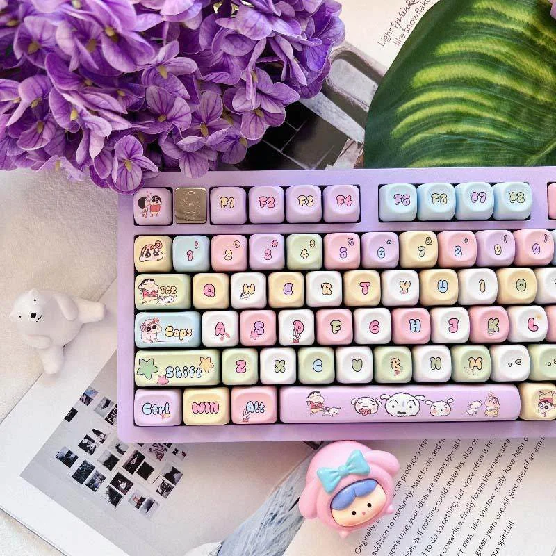 A whimsical Crayon Shin-chan PBT keycap set showcasing its exclusive blue-purple anime character designs from various angles.