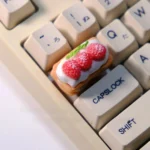 Close-up views of the handcrafted Cream Raspberry Layer artisan TAB keycap, showcasing its delicate layered design, sweet cream, and vibrant raspberry design.