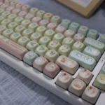 Adorable pink PBT cute cat keycaps set, featuring charming pastel pink and white whimsical cat designs. Durable and playful.