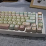 Adorable pink PBT cute cat keycaps set showcasing various angles, highlighting the charming pastel design and durable material for whimsical keyboards.