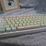 Adorable pink and white PBT cute cat keycaps set for a playful keyboard. Durable PBT material with charming cartoon cat designs.