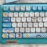 Vibrant Doraemon PBT dye-sub keycaps set displayed from multiple angles, showcasing iconic characters and whimsical gadgets for a playful keyboard setup.
