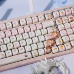 Whimsical Dream Island PBT dye-sub keycaps set from a distinct angle, revealing ethereal islandscapes and soft, dreamy colors. Highlights the artistic fan.