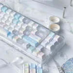 A collection of whimsical iridescent Dreamscape glitter keycap set, made of transparent PC, captured from diverse angles, highlighting their ethereal glow and playful design.