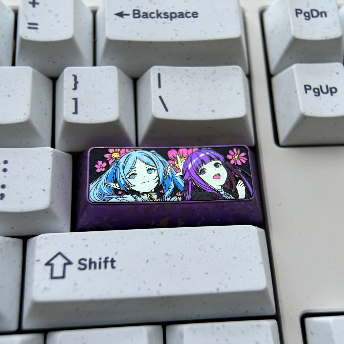 Premium Frieren & Fern titanium artisan keycap, showcasing vibrant character art on polished metal. A high-quality collectible Frieren keycap.