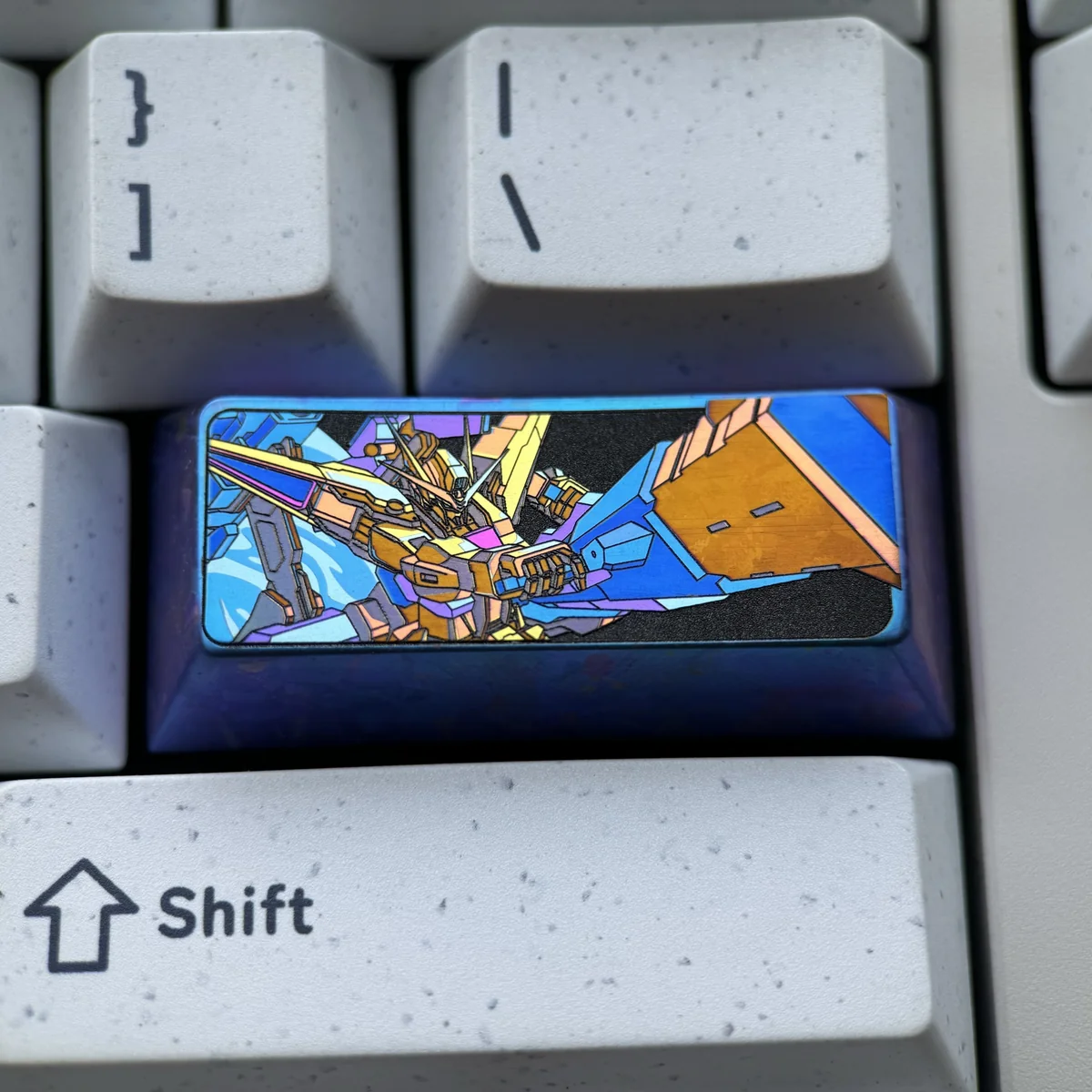 A vibrant anodized Gundam Titanium Keycap, showcasing its intricate mecha design and premium titanium alloy from multiple angles.