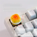 Gallery of whimsical handcrafted artisan keycaps, featuring realistic miniature baked desserts and sweet treats in various close-up views.