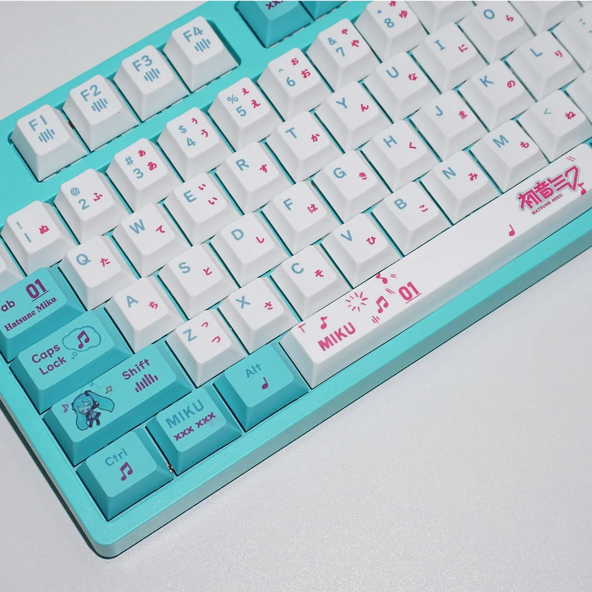 Artistic product shots of Hatsune Miku keycap set, revealing their radiant 4-sided translucent glow and vibrant character details from various perspective angles.