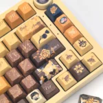 Exclusive Navia Elegance custom mechanical keycaps set, beautifully displayed from multiple angles with intricate amber, gold, and black rose motifs.
