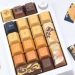 Navia Elegance custom mechanical keycaps set, showcasing intricate rose motifs in amber, gold, and black from multiple premium angles.