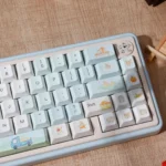 Whimsical Summer Orange Cat PBT Keycap Set, showcasing vibrant, playful orange cat illustrations and soft pastel summer motifs from multiple angles.