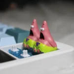 Multiple views of a whimsical handmade pink Patrick Star resin artisan keycap, highlighting its detailed craftsmanship as a beloved cartoon character.