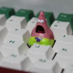 A whimsical handmade Patrick Star keycap, crafted from detailed pink resin, showcasing the beloved cartoon character as a unique artisan accessory.