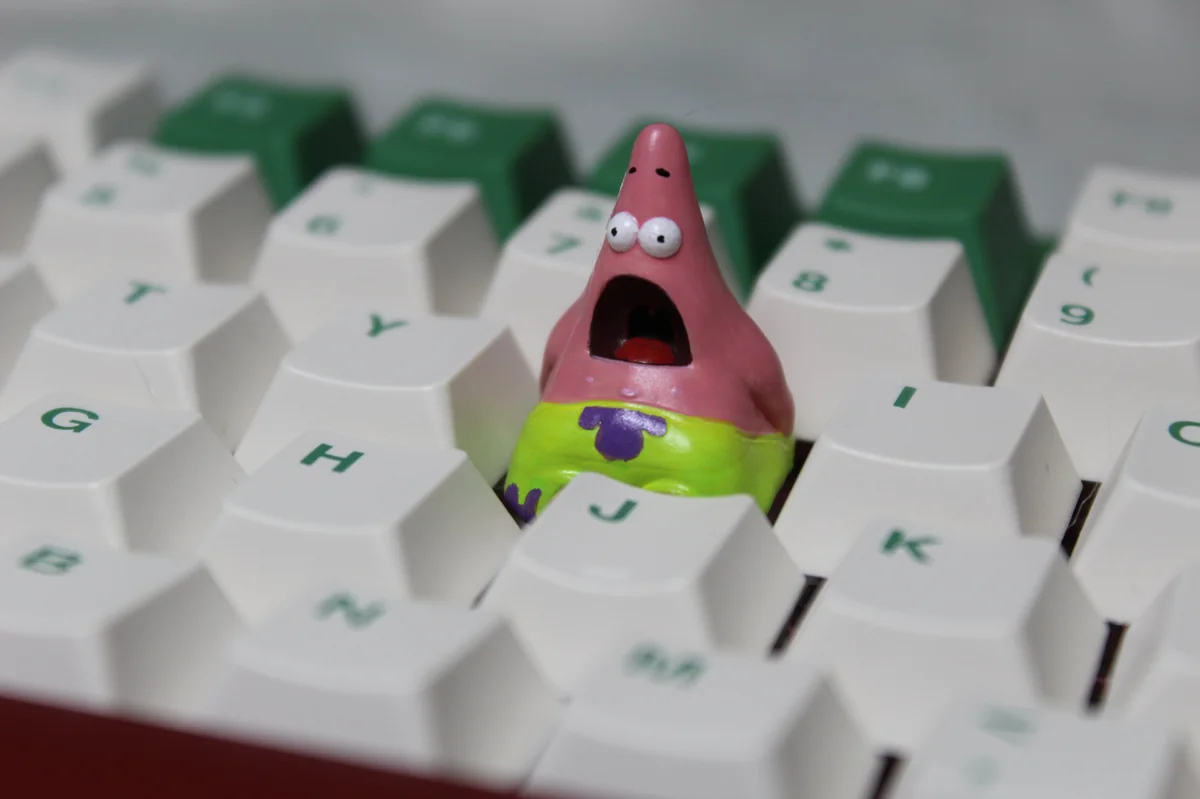 A whimsical handmade Patrick Star keycap, crafted from detailed pink resin, showcasing the beloved cartoon character as a unique artisan accessory.