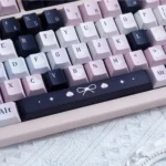 Enigmatic black and vibrant pink artistic PBT dye-sub keycaps set, revealing their unique, subtle legends from diverse angles.