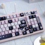 A gallery of enigmatic black and vibrant pink artistic PBT keycaps set, featuring unique dye-sub legends viewed from various angles, highlighting their mystical design.