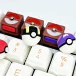Showcasing vibrant 3D okemon Poke Ball, Great Ball, and Master Ball keycaps from various angles, highlighting their iconic sculpted form.