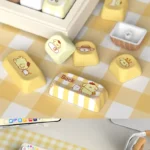 Various angles of the adorable Pompompurin PBT keycap set, featuring cheerful yellow and brown character designs and durable PBT quality.