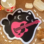 Views of the adorable Punk Kitty Mouse Pad, with its whimsical black and pink cat, punk accents, and unique irregular shape. A playful desk accessory.