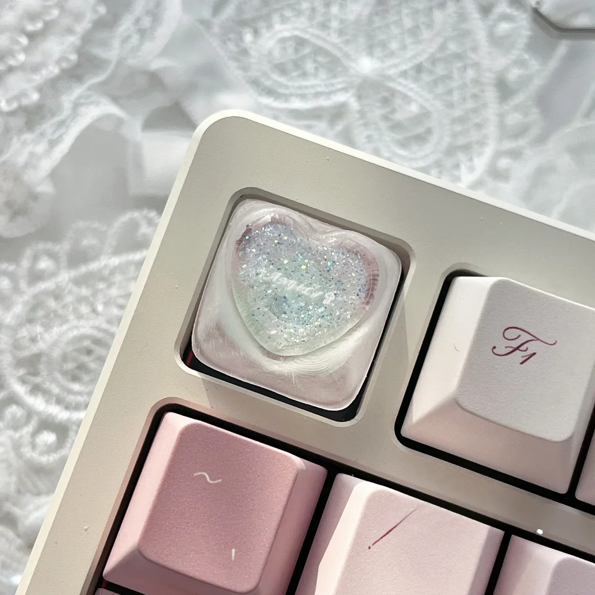 Handcrafted translucent resin heart keycap showcasing delicate angelic motifs from various angles, embodying romantic charm.