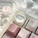 Handcrafted translucent resin heart keycap with delicate angelic motifs, shown from various angles to highlight its romantic charm.