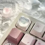 Handcrafted translucent resin heart keycap viewed from multiple angles, revealing its delicate embedded romantic heart and angelic motifs.