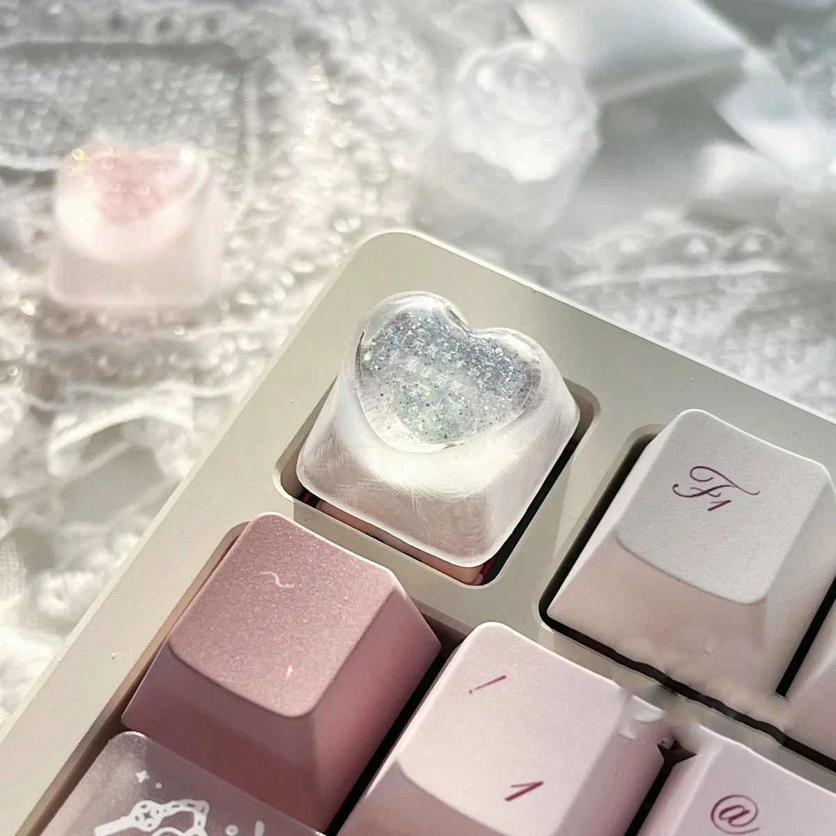 Handcrafted translucent resin heart keycap viewed from multiple angles, revealing its delicate embedded romantic heart and angelic motifs.