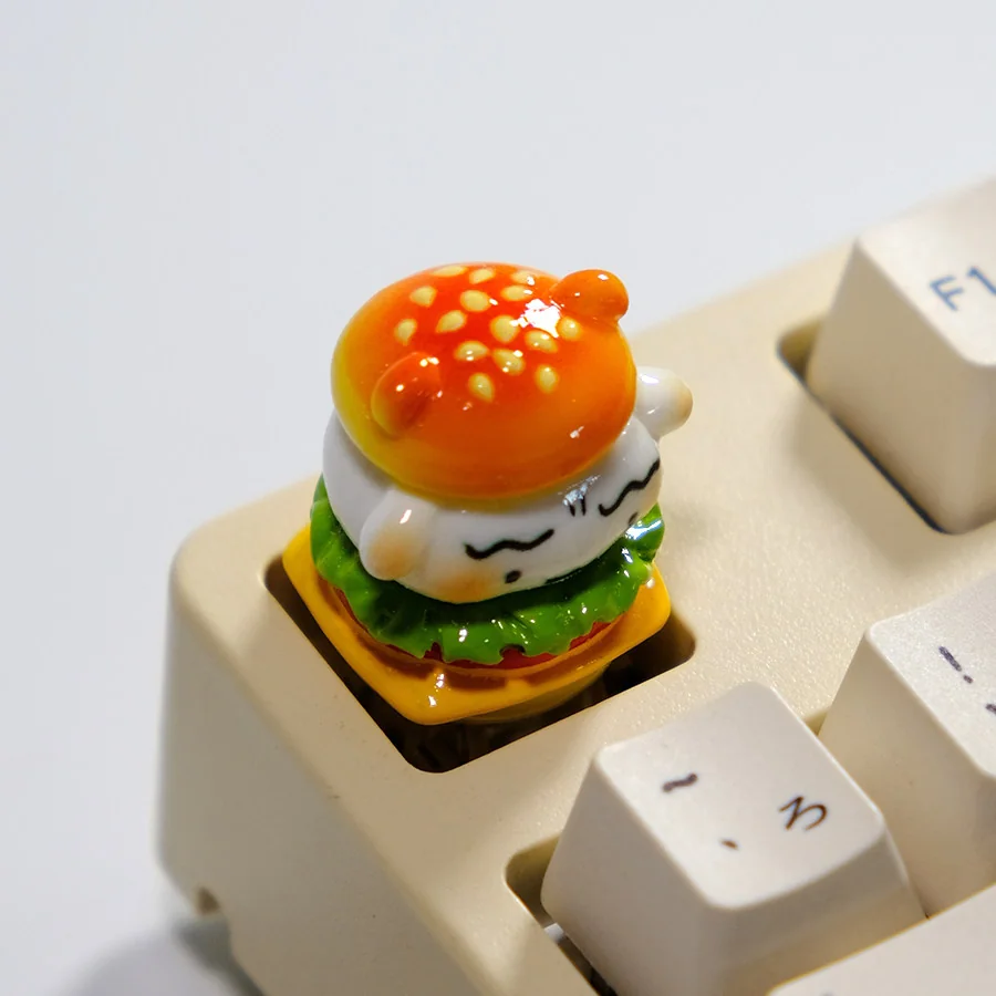 A close-up view of the handcrafted Crayon Shin-chan Shiro artisan keycap, showcasing Shiro whimsically emerging from a meticulously sculpted resin hamburger design.
