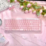 Pastel pink Stylish X100Pro Tri-Mode Membrane Keyboard featuring a cute cat charm, silent keys, and versatile tri-mode connectivity.