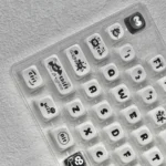 Susuwatari PBT Dye-sub keycaps set displayed on a minimalist background, showcasing the enchanting and playful characters.