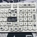 Whimsical Ghibli Susuwatari PBT dye-sub keycaps set, showing various angles. Dark background, playful Soot Sprites for a nostalgic keyboard.