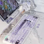 Handcrafted Ethereal Swan Realm Keycap Set. Multiple views showcasing translucent double-layer amber, deep purple hues, and delicate swan motif.