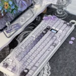 Multiple views of the handcrafted Ethereal Swan Realm Keycap set, showcasing its translucent amber and deep purple double-layer design with an intricate design.